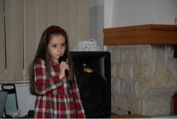 Dziewczynka śpiewa kolędę do mikrofonu